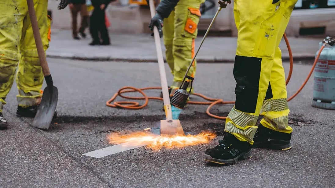 Straßenarbeiter bringen eine Markierung an