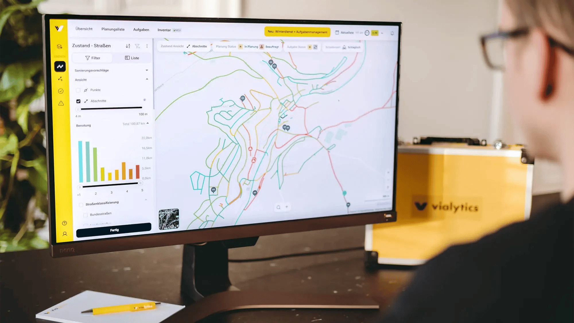 Person sitzt vor einem Bildschirm und bedient das vialytics Web-System
